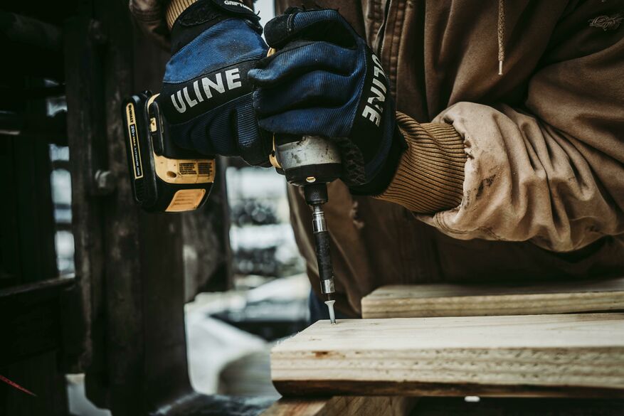 This image depicts a person installing a framework of a deck structure.