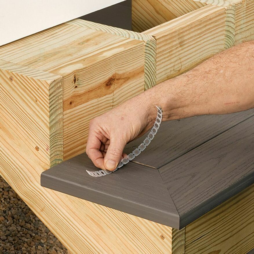 A close-up of a deck fastener being applied to a deck step.