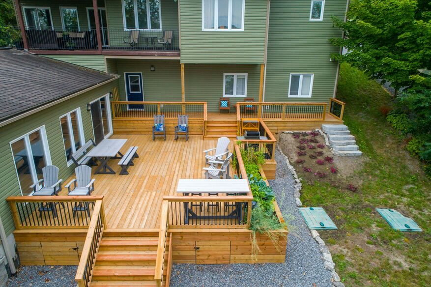 A green house has a large back deck with ample seating for outdoor entertaining.