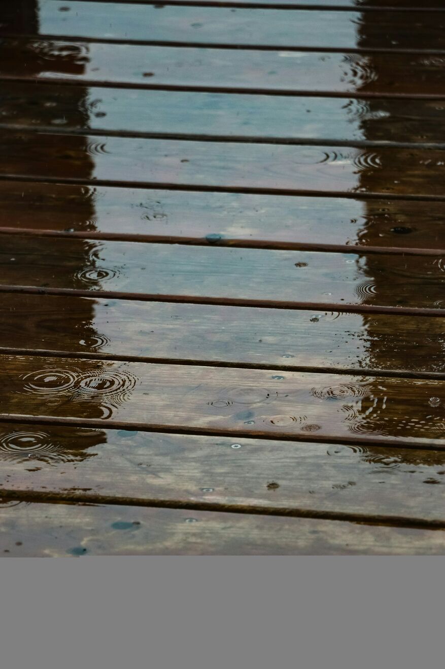 A close-up image shows a deck covered with water from a rainstorm.