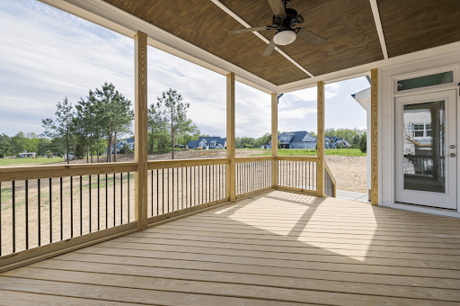 A completed wooden deck overlooks a backyard.